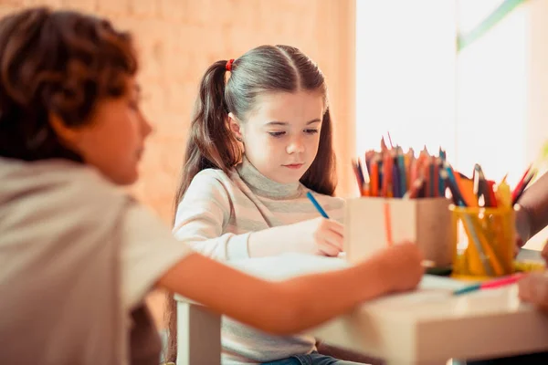 Sanat dersi boyunca renkli kalemlerle konsantre olmuş kız rüzgârı. — Stok fotoğraf