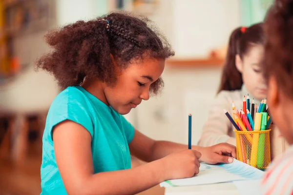 Lány rajz egy kék ceruzával a művészeti órán — Stock Fotó