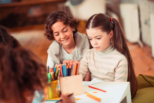 Хлопчик і дівчинка малюють кольоровими олівцями разом — стокове фото
