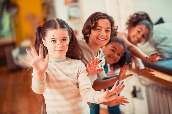 Des enfants joyeux jouant avec des peintures pendant le cours d'art — Photo