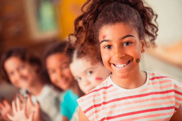 Sonriente chica siendo manchada con acuarelas brillantes —  Fotos de Stock