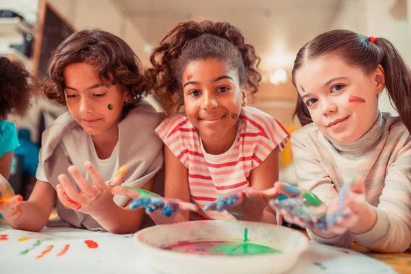 Crianças felizes pintando com os dedos na escola — Fotografia de Stock