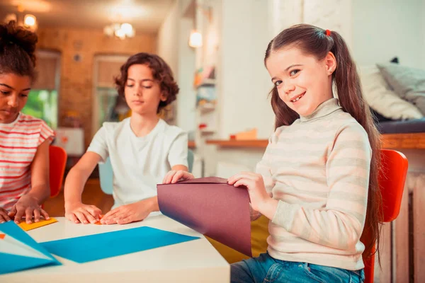 Meisje maken origami van het vel papier — Stockfoto