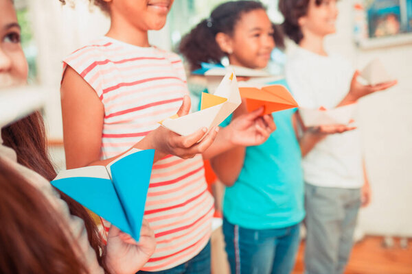 Group of schoolchildren holding their colorful paper crafts