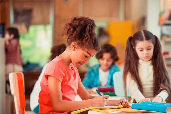 Konzentriertes Mädchen arbeitet an ihrer Schulaufgabe — Stockfoto