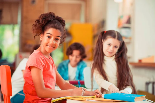 Leende flicka gör sina läxor tillsammans med sin klasskamrat — Stockfoto