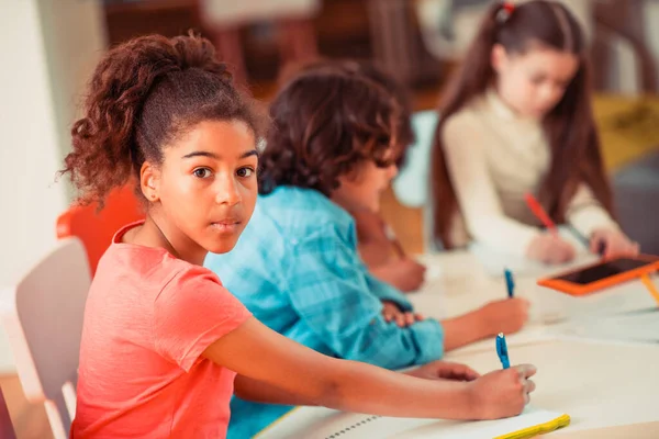 Mädchen macht ihre Schreibaufgabe in der Schule — Stockfoto