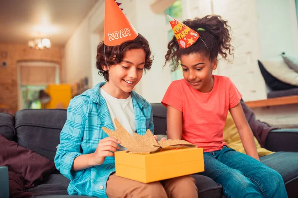 Sorridente ragazzo scartando il suo grande regalo di compleanno — Foto Stock