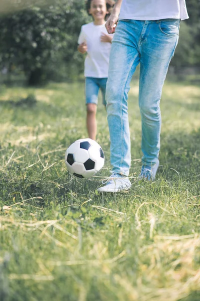 Niño de pelo oscuro y su padre corriendo con la pelota — Foto de Stock