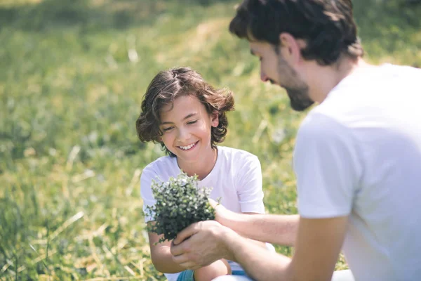 Father giving the plant to his son, the boy smiling — Stock Photo, Image