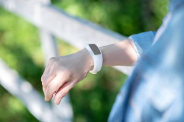 Dışarıda yürürken spor aleti takan yaşlı bir kadın.