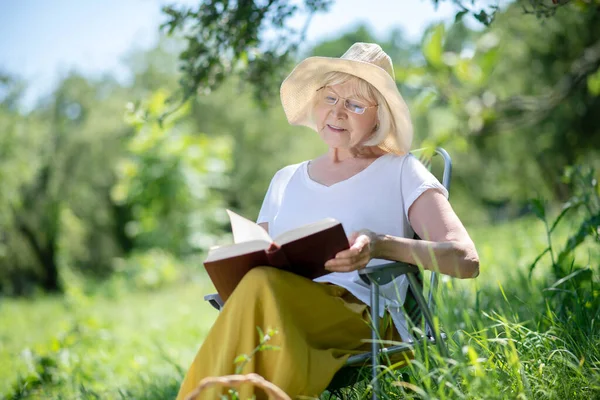 Vrouw die een boek leest in de frisse lucht — Stockfoto