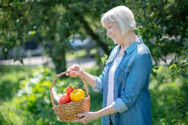 Äldre kvinna njuter av färska och mogna grönsaker — Stockfoto