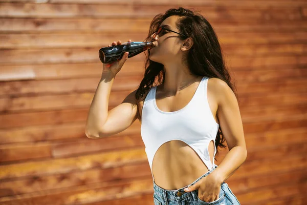 Beautiful brunette girl in white top drinking cola — Stock Photo, Image