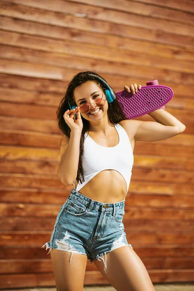 Vacker brunett flicka med skateboard känsla strömförande — Stockfoto