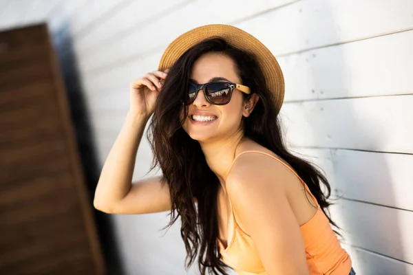 Mooi brunette meisje in een stro hoed poseren kijken vrolijk — Stockfoto