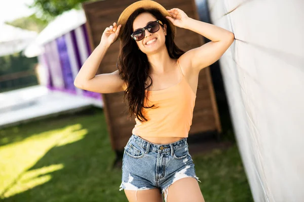 Mooi brunette meisje in jeans shorts op zoek gelukkig — Stockfoto