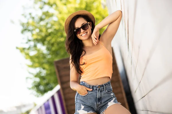 Hezká brunetka dívka v džínách kraťasy vypadají báječně — Stock fotografie