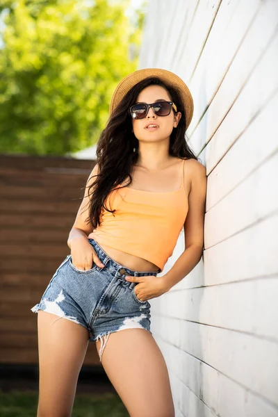 Hezká brunetka dívka v džínách kraťasy pózování — Stock fotografie