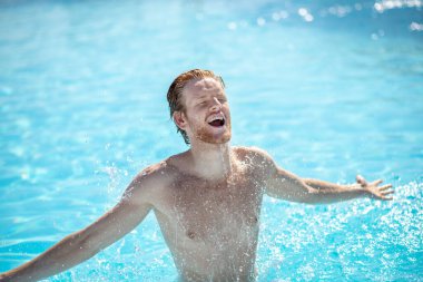 Neşeli adam beline kadar suyun içinde, gözleri kapalı