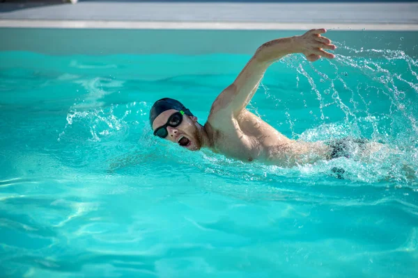 Mannelijke uitstekende zwemmer bewegend in zwembadwater — Stockfoto