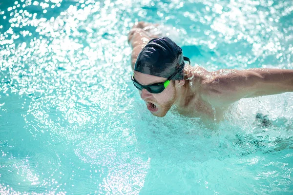 Homem em óculos de natação tendo um treino na piscina — Fotografia de Stock