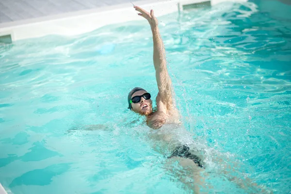 Swimmer swimming on his back arm straight raised up. — Stock Photo, Image