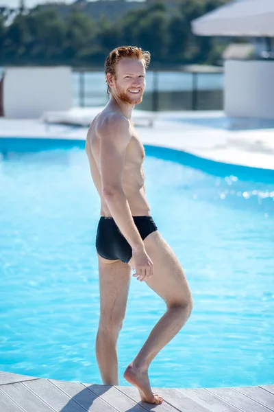 Tall athletic man turning back near the pool. Stock Photo by ©Dmyrto_Z  395547816