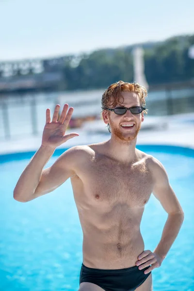 Man in sunglasses raised his hand in greeting — Stock Photo, Image