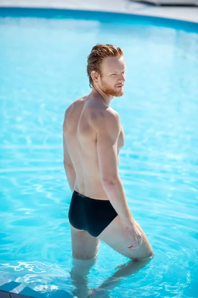 Jovem entra calmamente na piscina — Fotografia de Stock