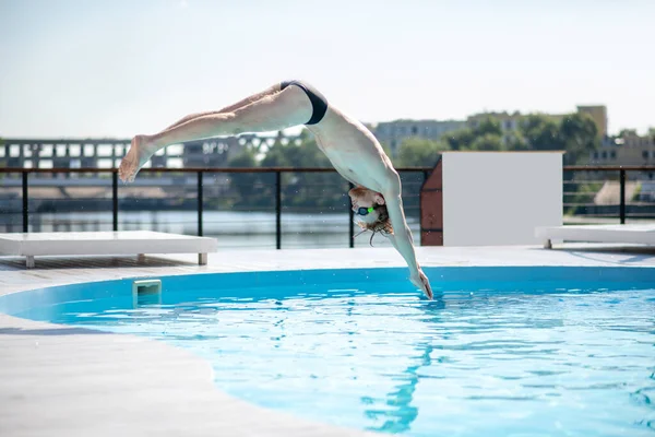 Homme en train de sauter par-dessus l'eau dans la piscine — Photo
