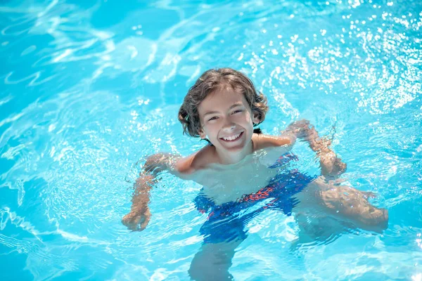 Tanned boy shoulder-length in swimming pool water — Stock Photo, Image