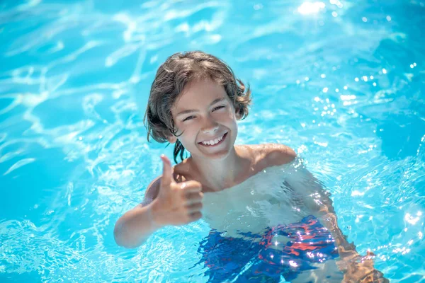Boy in water showing gesture everything is fine — Stock Photo, Image