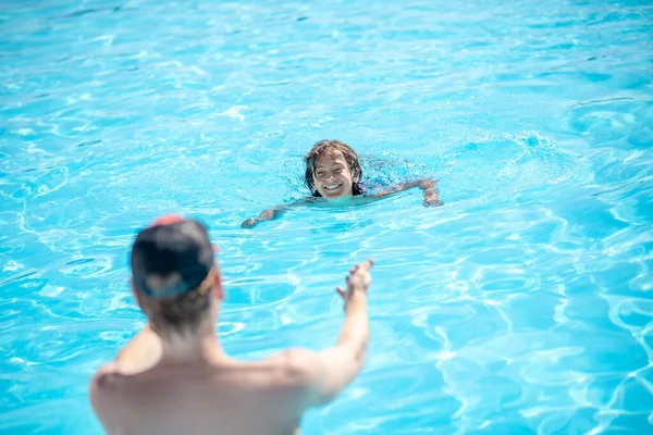 Mann mit ausgestrecktem Rücken zu schwimmendem Jungen — Stockfoto