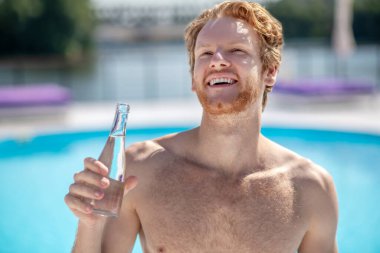 Elinde bir şişe su olan mutlu bir adam..