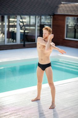 Havuzun yanında çıplak ayaklı bir sporcu.