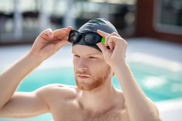 Young man in swimming cap clothing swimming goggles — Stock Photo, Image