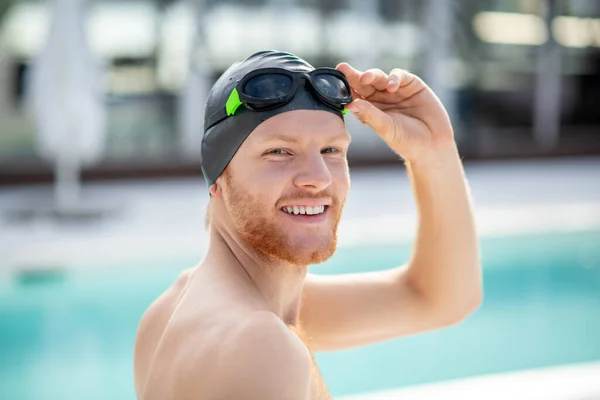 Homem sorridente virou sua cabeça nadador em touca de natação — Fotografia de Stock