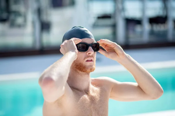 Serious swimmer in swimming goggles near the pool — Stock Photo, Image