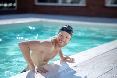 Havuzdaki gülümseyen adam yan bakıyor