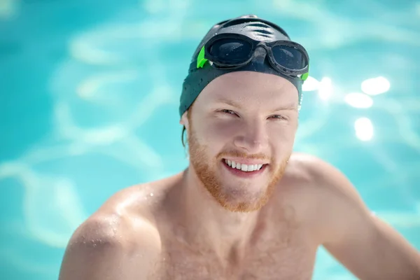 Succesvolle jonge bebaarde man met zwemmuts — Stockfoto