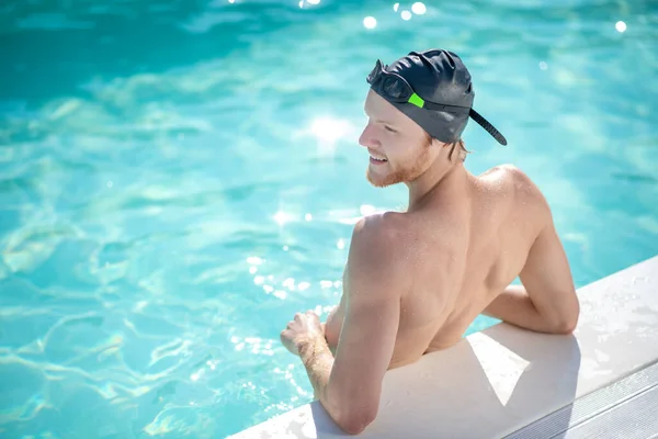 Mannelijke zwemmer rustend in water in het zwembad — Stockfoto