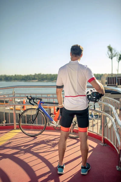 Hombre en ropa deportiva de ciclismo de pie con la espalda — Foto de Stock