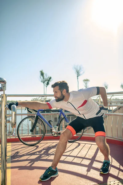 Man diligently doing warm-up and squats outdoors — Stock Photo, Image