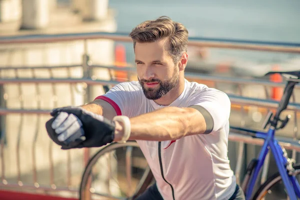 Hombre enérgico con los brazos extendidos haciendo ejercicio al aire libre — Foto de Stock