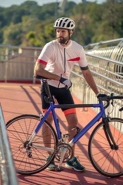 Велосипедист, стоящий на мосту — стоковое фото