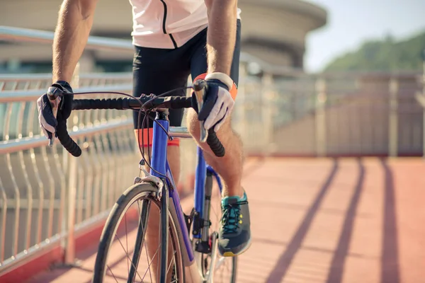 Pies de ciclista pedaleando una bicicleta en el puente — Foto de Stock