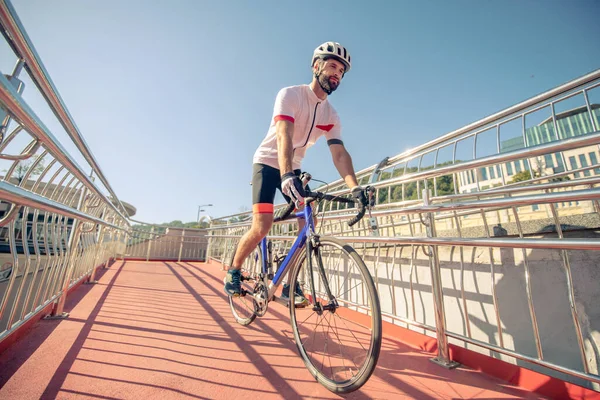 Велосипедист в спортивном костюме на мосту — стоковое фото