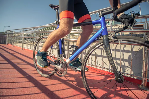 Pies masculinos en zapatillas de deporte en pedales de bicicleta en movimiento — Foto de Stock