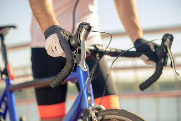 Manos de hombre en guantes deportivos sosteniendo el manillar de bicicleta — Foto de Stock